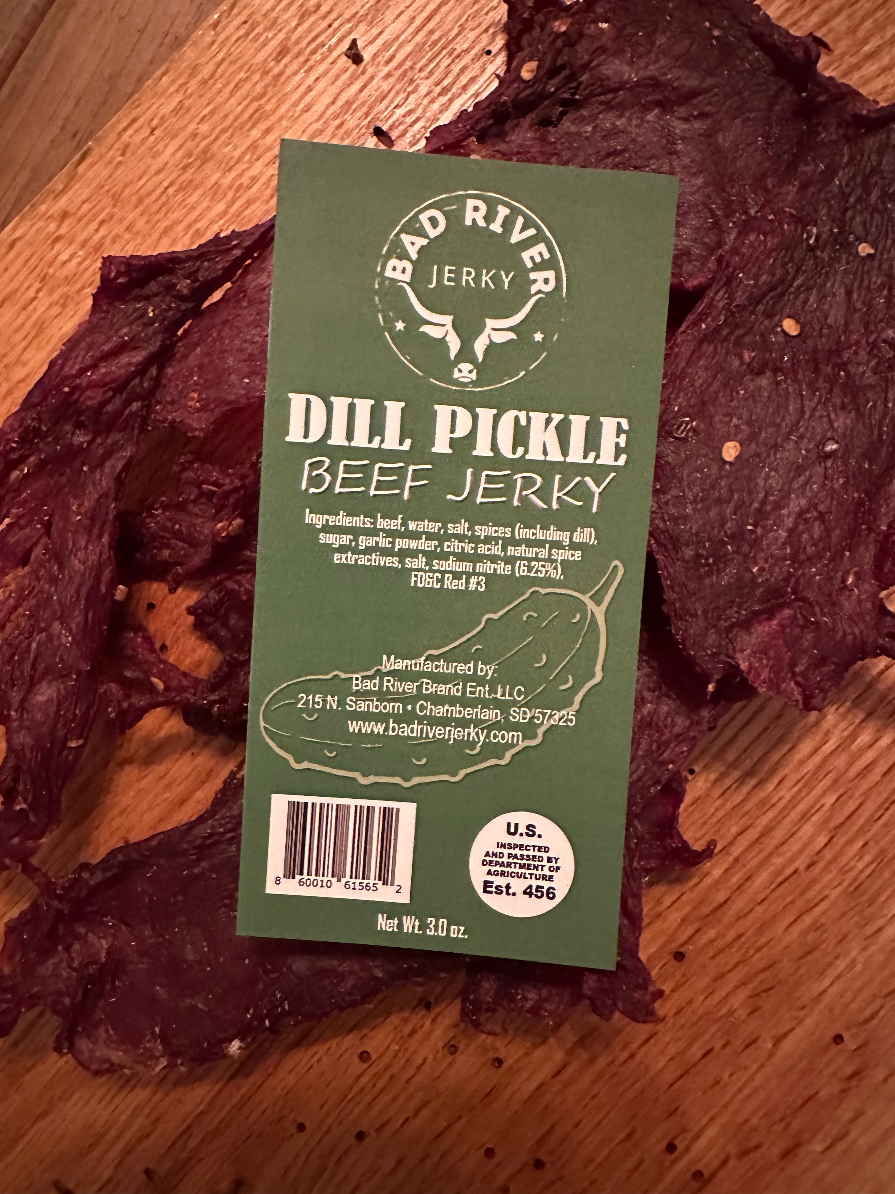 Dill pickle beef jerky pieces – close-up of hand-torn texture